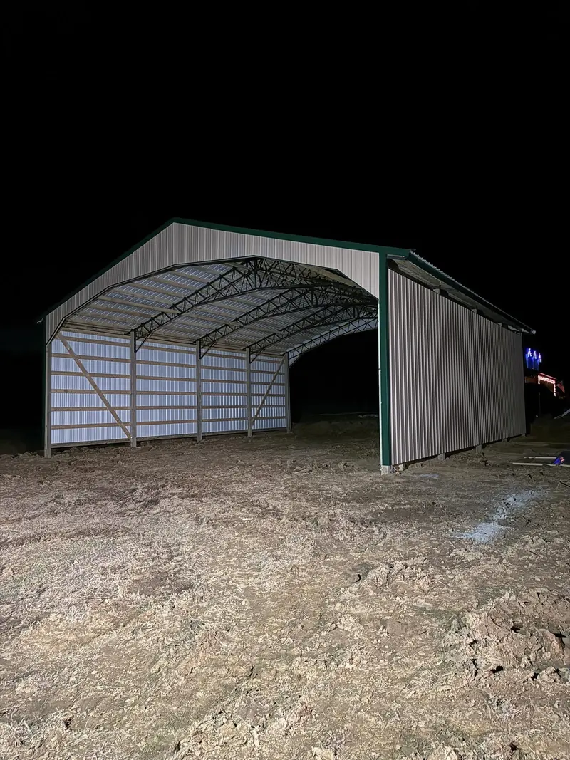 Open-ended pole building with metal walls and roof at night
