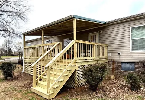 New covered deck with metal roof, railing and stairs on a manufactured home