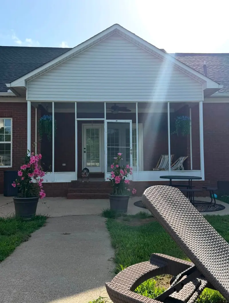 Screened porch on the back of a brick home