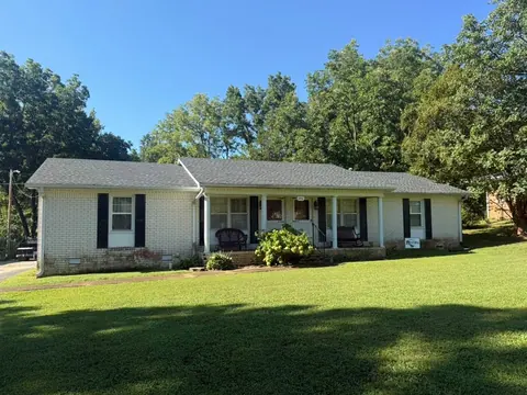 Brick ranch home with a gray shingle roof